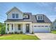 Charming two-story home with white brick, a welcoming front porch, and a two-car garage at 13605 Tranquil Day Dr, Matthews, NC 28105