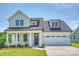 Charming two-story home features a white painted brick facade, attached garage, and well-manicured lawn at 13605 Tranquil Day Dr, Matthews, NC 28105