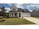 Charming two-story home with a two car garage, a manicured lawn, and beautiful landscaping at 13605 Tranquil Day Dr, Matthews, NC 28105