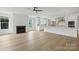 Bright open-concept living room with hardwood floors, fireplace, and modern ceiling fan at 13605 Tranquil Day Dr, Matthews, NC 28105
