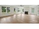 Bright living room with light hardwood floors, a fireplace, and large windows at 13605 Tranquil Day Dr, Matthews, NC 28105