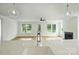 Bright, open-concept living area with hardwood floors, a fireplace, and large windows overlooking the landscaped yard at 13605 Tranquil Day Dr, Matthews, NC 28105
