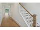 Elegant staircase with wood treads and white risers, leading to the upper level of the home at 13605 Tranquil Day Dr, Matthews, NC 28105