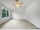 A spacious bedroom features neutral carpeting, a large window, and a ceiling fan at 14056 Lyon Hill Ln, Huntersville, NC 28078