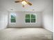 Bright, empty bedroom with neutral carpet, two large windows, and ample natural light at 14056 Lyon Hill Ln, Huntersville, NC 28078