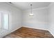 Bright dining room with wood flooring, a modern light fixture, and a glass panel door at 14056 Lyon Hill Ln, Huntersville, NC 28078