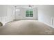 A bright living room with a large window, neutral carpeting, and a ceiling fan at 14056 Lyon Hill Ln, Huntersville, NC 28078