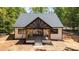 Wide back porch with elegant lighting, natural wood accents, and iron railing overlooking the yard at 1408 Bloomsberry Ln, Waxhaw, NC 28173