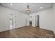 Open bedroom with hardwood floors, decorative chandelier, and access to other rooms at 1408 Bloomsberry Ln, Waxhaw, NC 28173