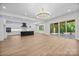 Open floor plan featuring a modern kitchen with white cabinets, a black island, and a view of the deck at 1408 Bloomsberry Ln, Waxhaw, NC 28173