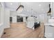 Expansive open living room featuring a modern kitchen island with waterfall countertops and custom lighting at 1408 Bloomsberry Ln, Waxhaw, NC 28173