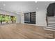 Open living room showcasing a fireplace, hardwood floors, staircase, and large glass doors to the deck at 1408 Bloomsberry Ln, Waxhaw, NC 28173