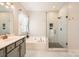 Bathroom featuring a soaking tub, glass shower, marble floors, and gray cabinets at 1455 Moss Creek Dr, Harrisburg, NC 28075