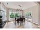 Bright dining area featuring hardwood floors, pendant lighting, and large windows with white curtains at 1455 Moss Creek Dr, Harrisburg, NC 28075