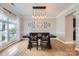 This dining room features hardwood floors, a decorative light fixture, a wall clock, and a large window that provides natural light at 1455 Moss Creek Dr, Harrisburg, NC 28075