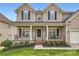 Inviting front porch with black metal railings and decorative columns offers curb appeal at 1455 Moss Creek Dr, Harrisburg, NC 28075