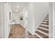 Inviting hallway featuring wood-look floors leading to the stairs and showcasing natural light at 15012 Meadows Hunt Ln # 157, Huntersville, NC 28078