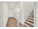 Hallway with wood floors leading to stairs, showcasing the open floor plan and neutral color palette at 15012 Meadows Hunt Ln # 157, Huntersville, NC 28078