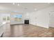 Open living space with a fireplace and large windows, highlighting the wood flooring and abundant natural light at 15012 Meadows Hunt Ln # 157, Huntersville, NC 28078