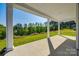 Covered back porch provides an outdoor living area with picturesque views of green trees and a blue sky at 18011 Wilbanks Dr, Charlotte, NC 28278