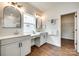 Bright bathroom featuring double sinks, stylish mirrors, wood-look tile flooring, and a view from the window at 18011 Wilbanks Dr, Charlotte, NC 28278