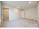 Bright bedroom featuring neutral tones, plush carpeting, and an open closet space for ample storage at 18011 Wilbanks Dr, Charlotte, NC 28278
