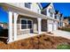 Beautiful home exterior with stone accents, white pillars, a two-car garage, and manicured front yard at 18011 Wilbanks Dr, Charlotte, NC 28278