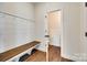Functional mudroom with a wood bench, coat hooks, and wood-look tile floor at 18011 Wilbanks Dr, Charlotte, NC 28278