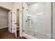 Contemporary shower with white marble-look tiles, glass door, and built-in corner shelves at 18011 Wilbanks Dr, Charlotte, NC 28278