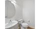 Half bathroom featuring a pedestal sink, toilet, and decorative round mirror at 2020 White Cedar Ln, Waxhaw, NC 28173