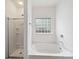 Bright bathroom featuring a glass block window, separate shower, and soaking tub at 2020 White Cedar Ln, Waxhaw, NC 28173