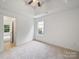 Neutral bedroom featuring a ceiling fan, plush carpeting, and abundant natural light at 2020 White Cedar Ln, Waxhaw, NC 28173