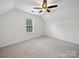 A carpeted bedroom featuring natural light from a window and modern ceiling fan at 2020 White Cedar Ln, Waxhaw, NC 28173