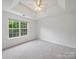 Bright bedroom featuring a tray ceiling, carpet flooring, and large windows at 2020 White Cedar Ln, Waxhaw, NC 28173