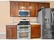 Kitchen features stainless steel microwave, double oven, and fridge; dark cabinets; and gray countertops at 2020 White Cedar Ln, Waxhaw, NC 28173