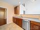 Open kitchen features stainless steel dishwasher, double sink, and dark wood cabinets at 2020 White Cedar Ln, Waxhaw, NC 28173