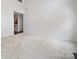 Spacious open concept living area featuring plush carpet and natural light with a view into the hallway at 2020 White Cedar Ln, Waxhaw, NC 28173