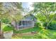 Backyard view of charming home with screened-in sun room and lush landscaping at 2915 Cherry Blossom Ct, Fort Mill, SC 29715