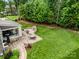 Aerial view of backyard with a covered patio, stone firepit, and lush landscaping at 320 Eden Hollow Ln, Weddington, NC 28104