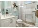 Bathroom with a white vanity, toilet, and shower with glass door, complemented by light-blue walls at 320 Eden Hollow Ln, Weddington, NC 28104