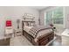 Comfortable bedroom with a wooden bed frame, black and white pillows, and a window with natural light at 320 Eden Hollow Ln, Weddington, NC 28104
