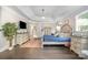 Tranquil bedroom with a tufted bed, large windows, hardwood floors, and a decorative plant at 320 Eden Hollow Ln, Weddington, NC 28104