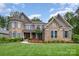 Stunning two-story home featuring stone and brick accents and a meticulously manicured lawn at 320 Eden Hollow Ln, Weddington, NC 28104