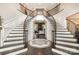 Grand foyer featuring a curved staircase, wood flooring, a decorative rug, and an inviting view into the living area at 320 Eden Hollow Ln, Weddington, NC 28104