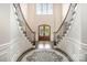 Elegant foyer with a curved staircase, dark wood floors, a decorative rug, and a stunning glass-paneled front door at 320 Eden Hollow Ln, Weddington, NC 28104