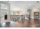 Spacious hallway featuring hardwood floors, decorative iron railings, and a view of the chandelier at 320 Eden Hollow Ln, Weddington, NC 28104
