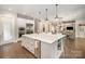 Bright kitchen features an island, stainless steel appliances, a view into the dining room, and custom cabinets at 320 Eden Hollow Ln, Weddington, NC 28104