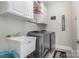 Modern laundry room with gray washer and dryer, white cabinets, and a utility sink at 320 Eden Hollow Ln, Weddington, NC 28104