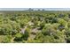 Aerial view of the home featuring a well-manicured lawn, lush trees, and a city skyline at 3400 Barfield Dr, Charlotte, NC 28217