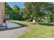 This backyard has a large grassy area, mature shade trees, and a small storage shed at 3400 Barfield Dr, Charlotte, NC 28217